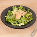 A salad in a black GET Etchedware bowl.