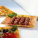 A GET Venetian melamine square plate with meatballs, olives, and salad on it.