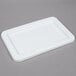 A white rectangular Winholt lid on a gray surface.