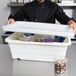A man placing a white Winholt lid on a container of food.