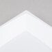A close-up of a white rectangular object with a grey background.
