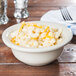 A Hall China ivory pot pie baking bowl filled with macaroni and cheese.