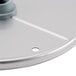 A close up of a Robot Coupe 5/64" silver metal slicing disc with a hole in it.