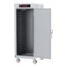 A white metal Metro C5 holding cabinet with shelves and solid doors.