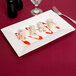 A rectangular white porcelain platter with a roll of food on it.