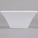 An Arcoroc white square flared bowl with a white border.