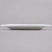 A white rectangular Arcoroc porcelain side plate with a curved edge.