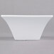A white square Arcoroc flared bowl on a gray surface.