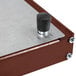 A metal box with a black knob on a black base.
