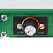 A close-up of a green and white control panel with a knob and a switch.
