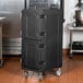 A black Carlisle Cateraide front loading insulated food pan carrier with wheels.