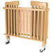 A natural wood L.A. Baby mini crib with wheels.