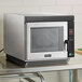 An Amana stainless steel commercial microwave oven on a counter.