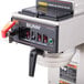 A Bunn commercial automatic coffee brewer with stainless steel funnels on a counter.