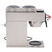A Bunn stainless steel commercial coffee maker with two black round warmers on top.