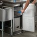 A man opening a stainless steel undercounter Scotsman gourmet cube ice machine.