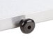 A black knob on a silver surface.