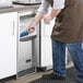 A man in a blue apron cleaning a Scotsman undercounter ice machine.