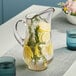 A Libbey glass pitcher filled with water, lemons, and rosemary.