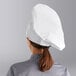A woman wearing a white Choice chef hat.