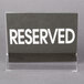 A Cal-Mil acrylic displayette with white text on a table.