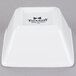 A bright white square Tuxton china bowl with black text reading "TuxTrendz Santorini" on the side.