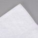 A white Oxford Gold Dobby bath towel on a gray surface.