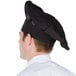 A man wearing a black Chef Revival chef hat.