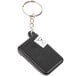 A black key chain with a black electronic device and a white label.