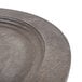 A Lodge oval wood underliner with a walnut finish on a table with a wood plate.