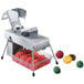 An Edlund electric fruit and vegetable slicer with tomatoes and other fruits on a counter.