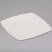 A white square Fineline plastic dessert plate with a white rim on a gray surface.