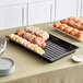 A black Cambro market tray of pastries on a table.