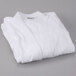 An Oxford Terry white bathrobe folded on a gray surface.