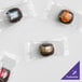 A group of small packages of customizable chocolate buttermints with clear wrappers.