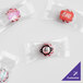 A group of clear plastic packages of pink and white star-shaped candy with custom logos.