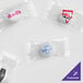 A group of small packages of white customizable chocolate pastel mints with clear wrappers.