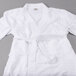 A pack of 12 white Oxford Terry bathrobes on a gray surface.