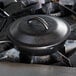 A Lodge cast iron cover on a cast iron pot on a stove.