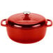 A Lodge Island Spice Red enameled cast iron dutch oven with a silver and red lid.