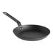 A Lodge pre-seasoned black carbon steel frying pan with a handle.