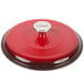 The red lid of a Lodge Island Spice Red enameled cast iron Dutch oven with a silver knob.