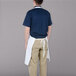 A man wearing a Chef Revival white apron with one pocket.