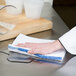 A hand using a Chef Revival blue stripe bar towel to clean a counter.