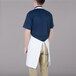 A man wearing a white Chef Revival bib apron with one pocket.