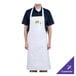 A man wearing a white Chef Revival bib apron with a green logo.