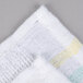 A white bar towel with yellow stripes.