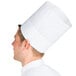 A man wearing a Chef Revival pinstripe chef hat with a white band.