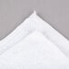 A close-up of a white Chef Revival bar towel with a torn edge.