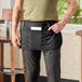 A man wearing a black Chef Revival waist apron with pockets.